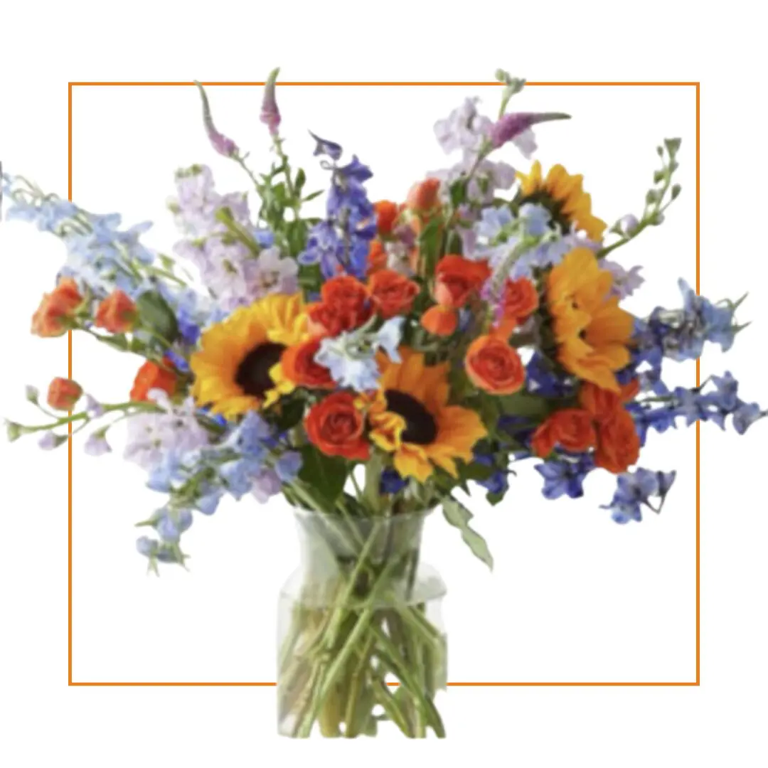 Vibrant mixed flower bouquet in glass vase.