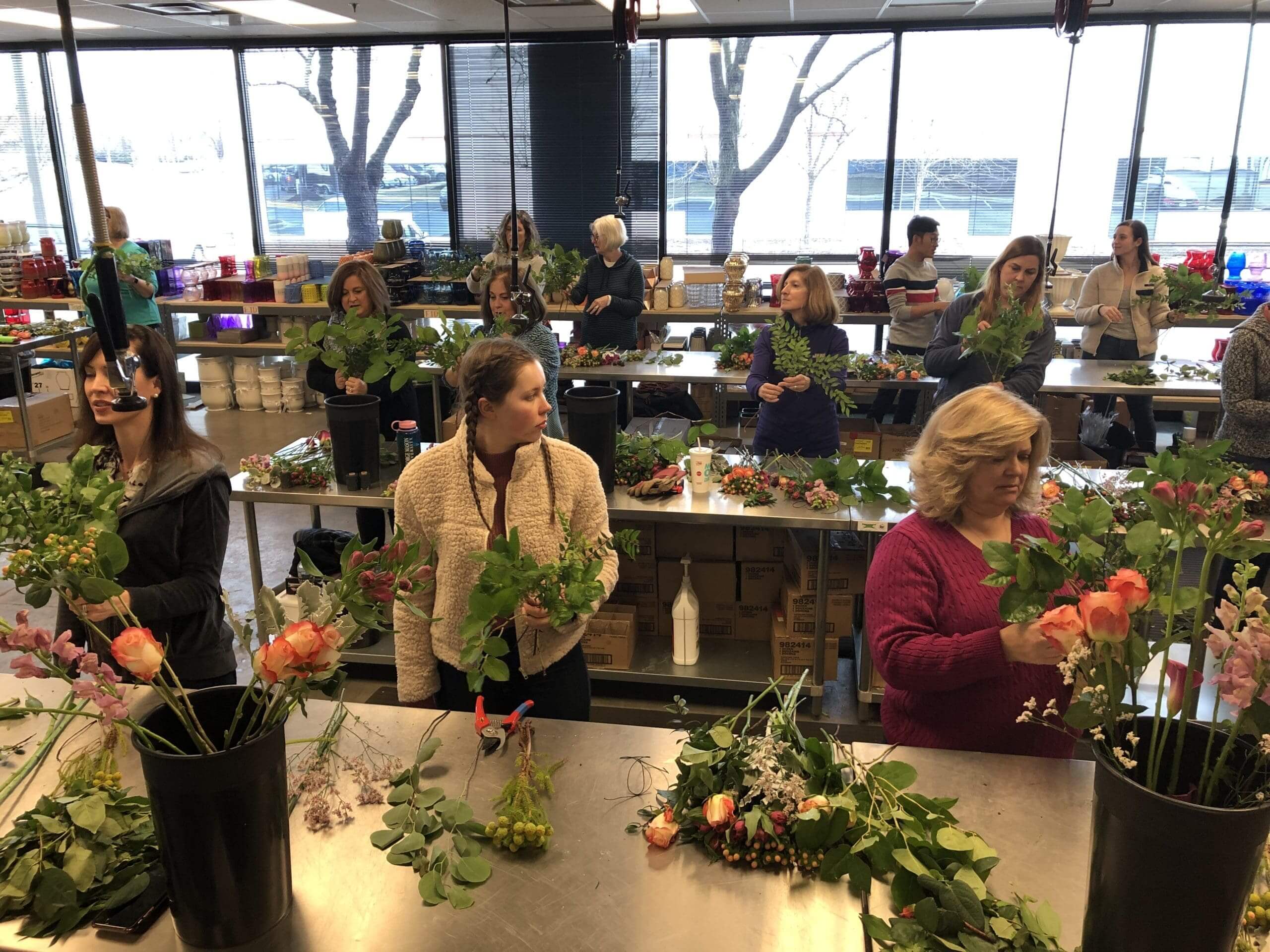 A group of people sitting around tables with flowers.