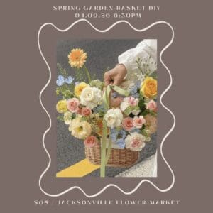 Basket of colorful flowers held by hand.