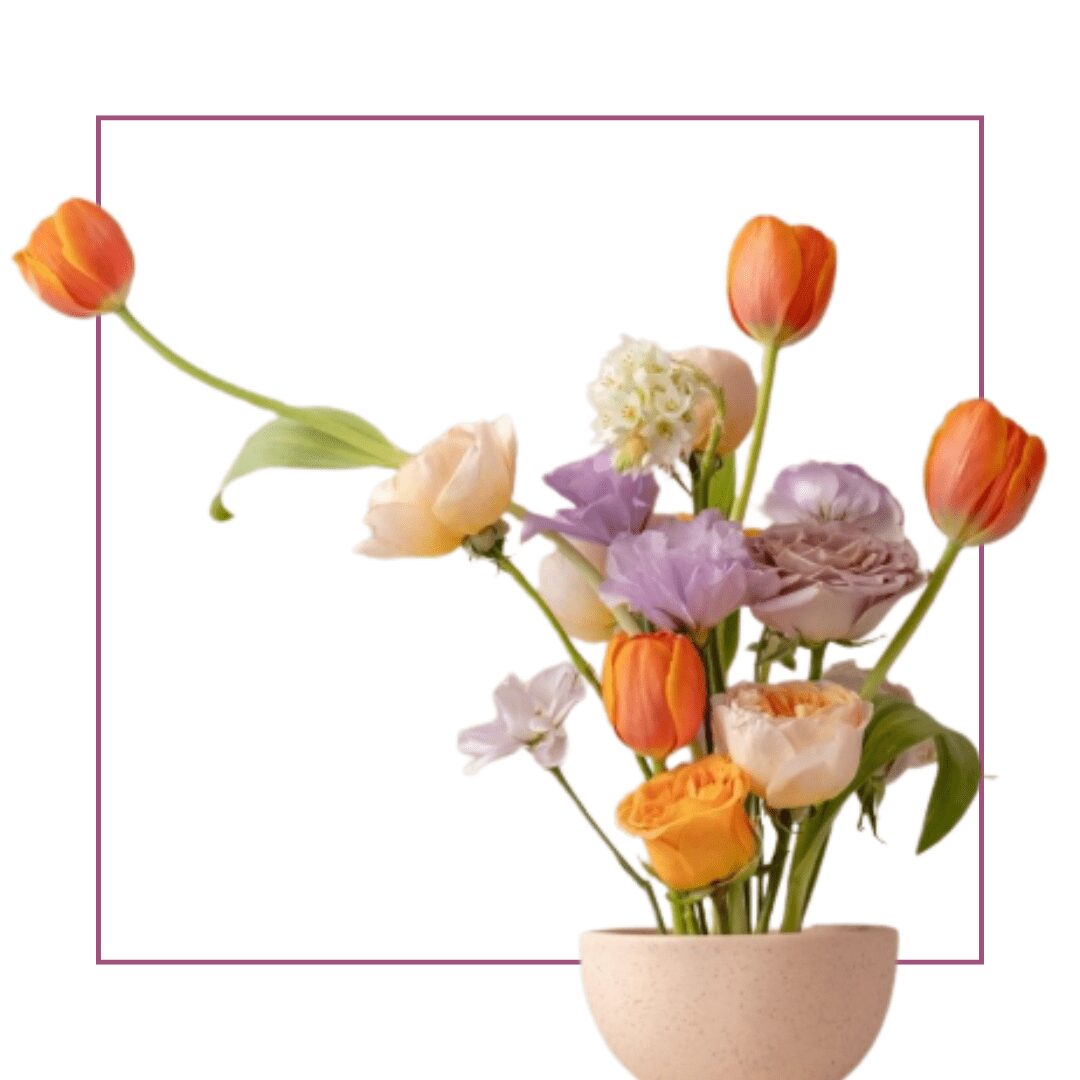 Orange tulips and pastel flowers in vase