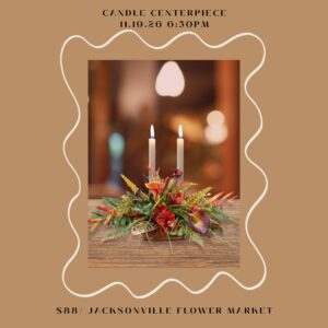 Two-candle autumn floral centerpiece on wooden table