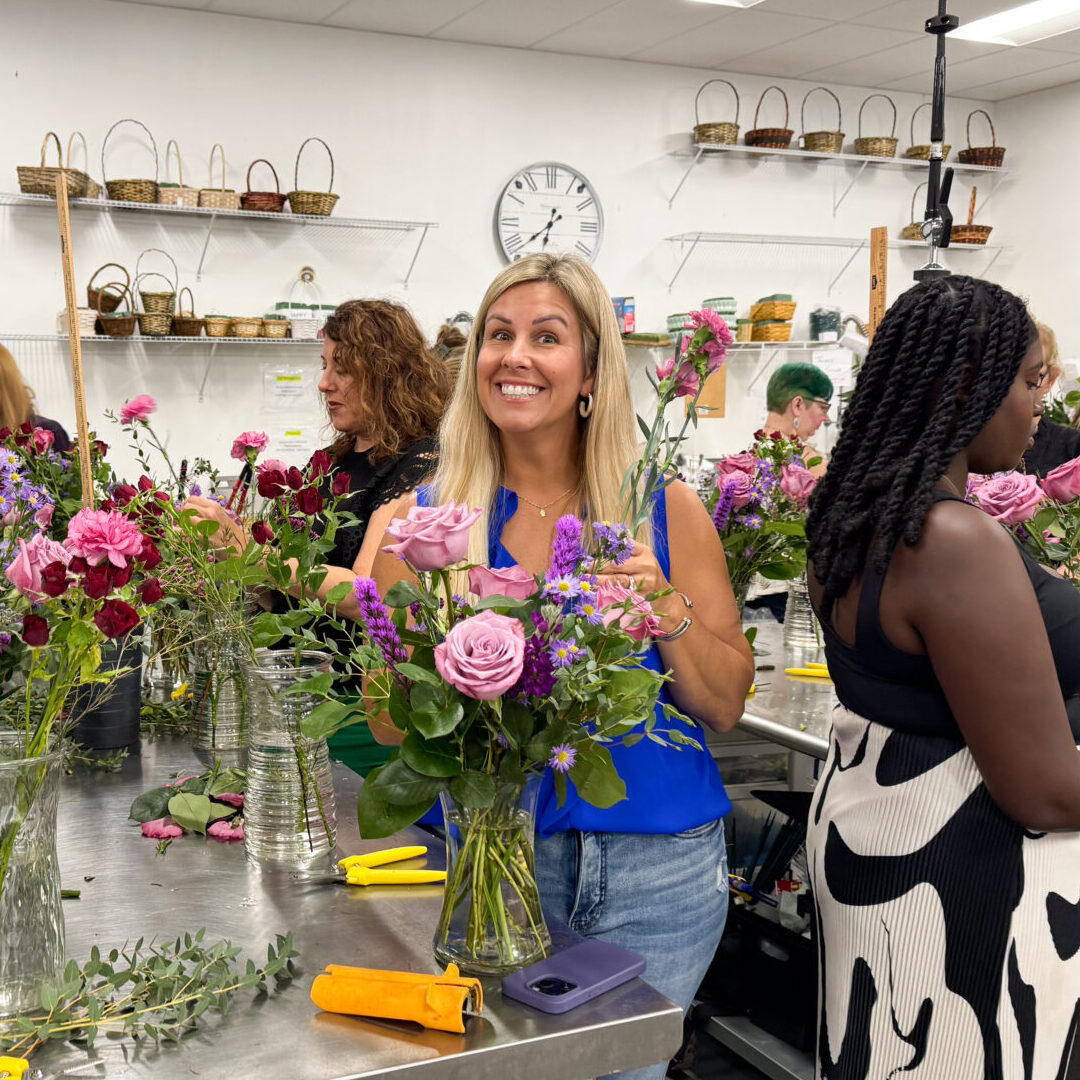 Woman smiling arranging flowers at workshop